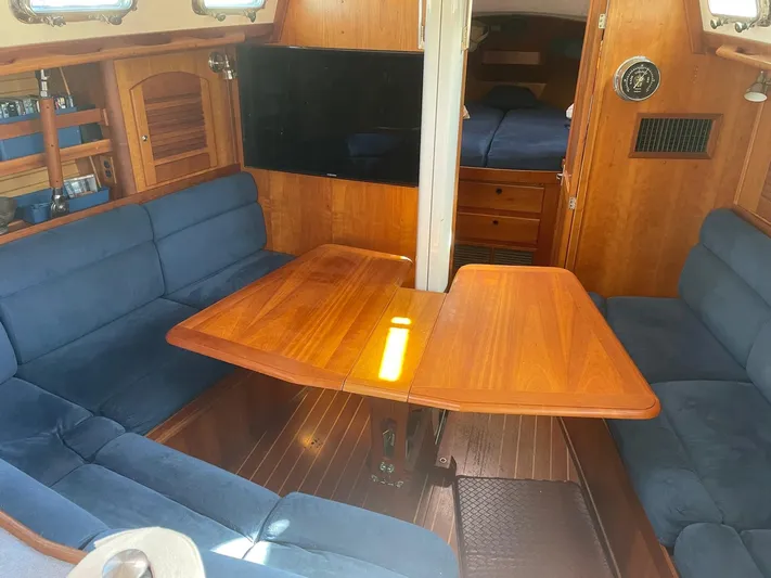 Caribou Yacht Photos Pics Interior of 2001 Sabre 402 sailboat with wooden table and blue seating.