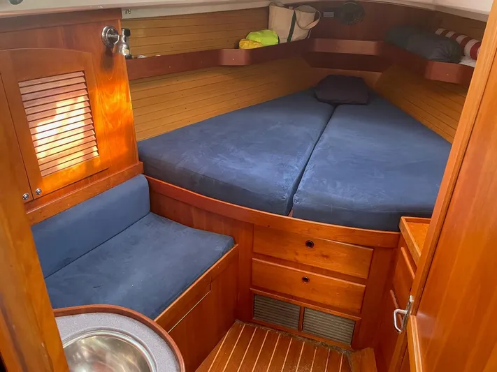 Caribou Yacht Photos Pics Cozy cabin interior of 2001 Sabre 402 sailboat with wooden finish and blue cushions.