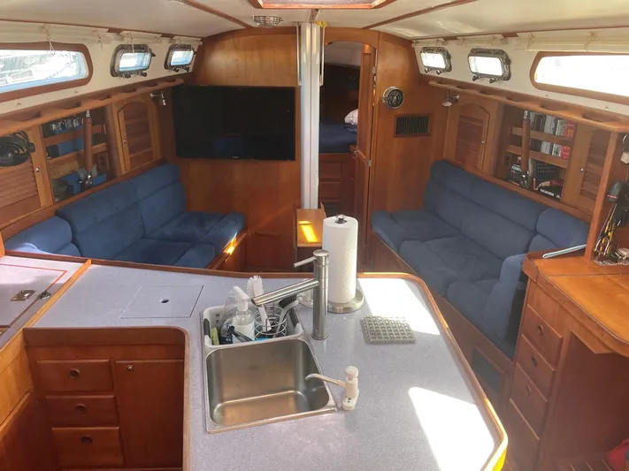 Caribou Yacht Photos Pics Interior of a 2001 Sabre 402 yacht with blue seating and wooden cabinetry.