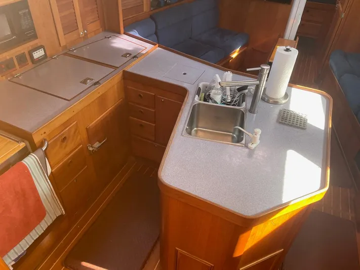 Caribou Yacht Photos Pics Interior of 2001 Sabre 402 yacht featuring a compact kitchen with sink and wooden cabinetry.