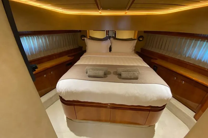 Ukiyo Yacht Photos Pics Luxurious bedroom interior of 2002 Ferretti Yachts 68, featuring elegant wood finishes and ambient lighting.