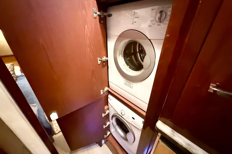 Seas The Day Yacht Photos Pics Laundry area with stacked washer and dryer in 2014 Sea Ray 580 Sundancer yacht.