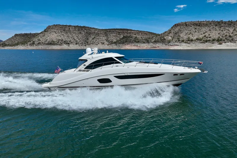 Seas The Day Yacht Photos Pics 2014 Sea Ray 580 Sundancer yacht cruising on a scenic lake with hills in the background.