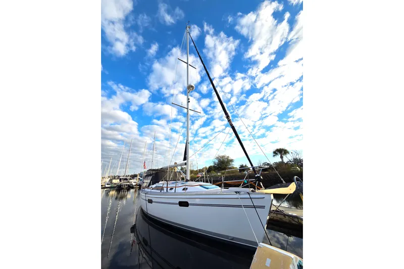 Here & Now Yacht Photos Pics 2021 Catalina 445 sailboat docked under a vibrant blue sky with clouds.