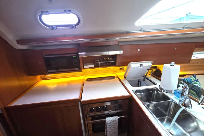 Here & Now Yacht Photos Pics Modern kitchen in a 2021 Catalina 445 yacht with microwave, stove, and double sink.