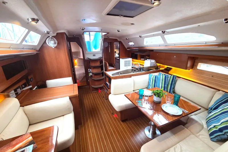 Here & Now Yacht Photos Pics Luxurious interior of 2021 Catalina 445 yacht with elegant wood finish and cozy seating area.