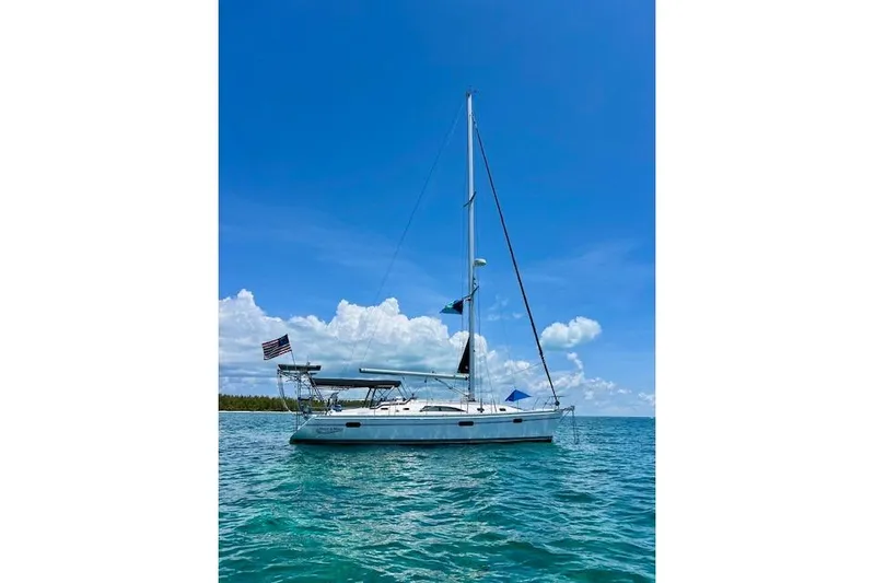 Here & Now Yacht Photos Pics Sailboat Catalina 445, 2021 model, anchored on clear blue water under a sunny sky.