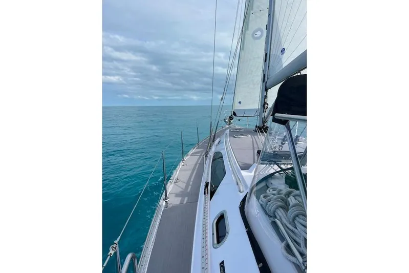 Here & Now Yacht Photos Pics Sailing on a 2021 Catalina 445 yacht in clear blue waters under a cloudy sky.