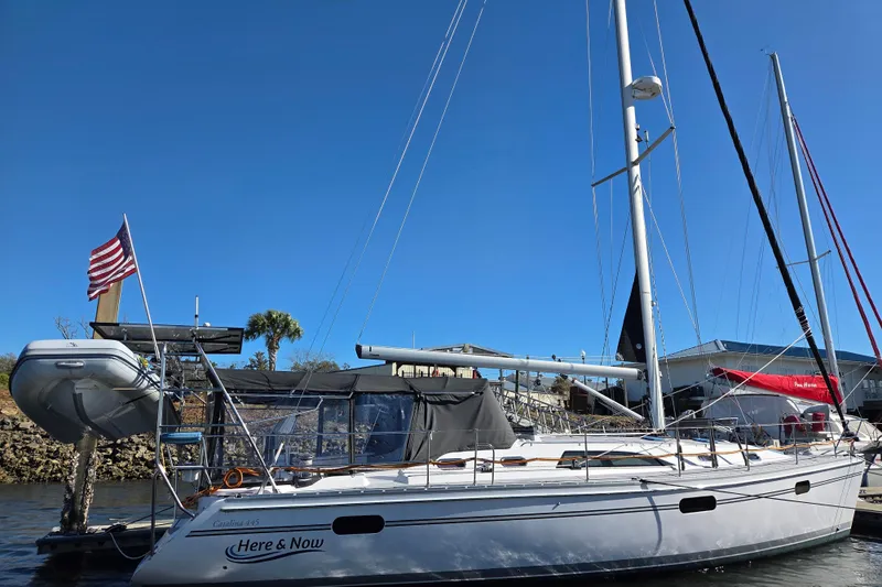 Here & Now Yacht Photos Pics 2021 Catalina 445 sailboat docked, featuring sleek design and American flag.