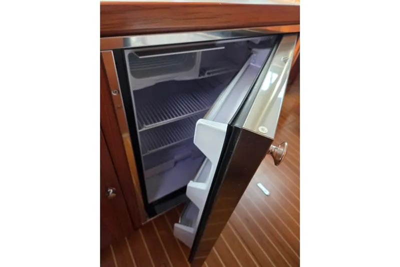 Here & Now Yacht Photos Pics Open refrigerator on Catalina 445 yacht, 2021 model, with wooden flooring.