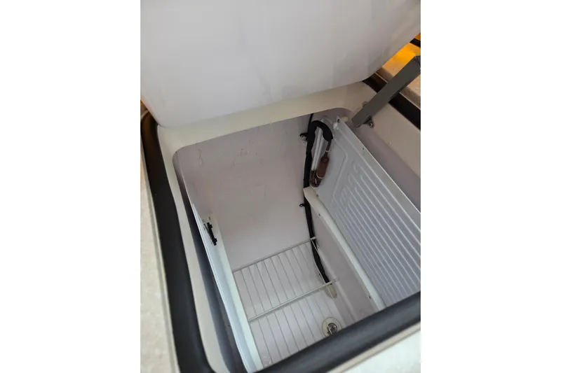 Here & Now Yacht Photos Pics Open storage compartment in 2021 Catalina 445 boat, featuring white interior and metal support.