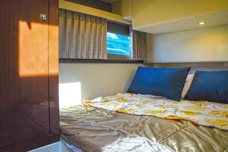  Yacht Photos Pics Cozy bedroom interior of 2020 Carver C40 yacht with sunlight and blue pillows.