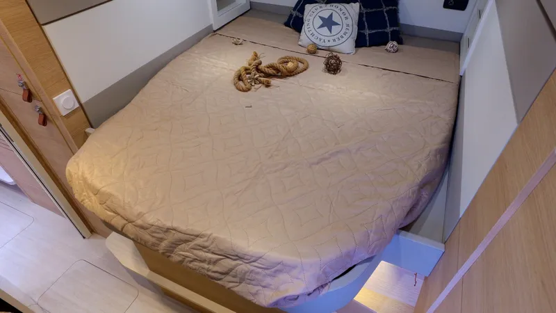 Tbd Yacht Photos Pics Cozy bedroom in 2025 Aventura 45 yacht with nautical decor and beige bedding.