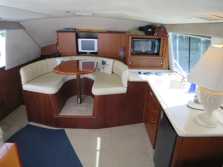 Bayou Bandit Yacht Photos Pics Interior of a 1999 Ocean Yachts boat with dining area, kitchenette, and TV.