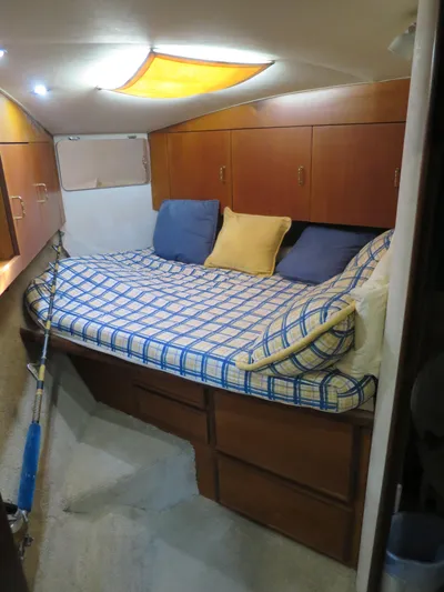 Bayou Bandit Yacht Photos Pics Cozy bedroom in a 1999 Ocean Yachts model with wooden cabinets and a checkered bedspread.