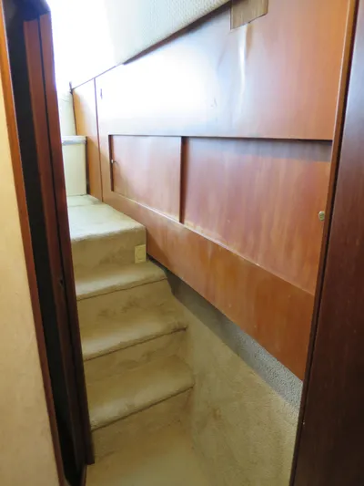 Bayou Bandit Yacht Photos Pics Staircase inside a 1999 Ocean Yachts model, featuring wooden paneling and carpeted steps.