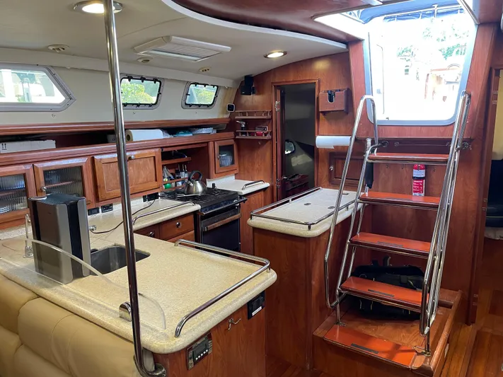 Sailing Diver Yacht Photos Pics Interior of 2010 Hunter 49 Aft Cockpit yacht with modern kitchen and wooden finishes.