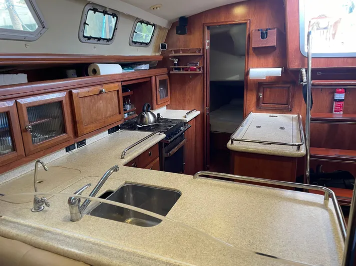 Sailing Diver Yacht Photos Pics Interior of 2010 Hunter 49 Aft Cockpit yacht kitchen with wooden cabinetry and modern appliances.