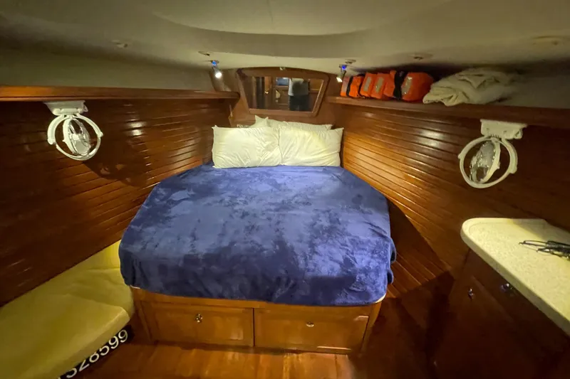 Sailing Diver Yacht Photos Pics Cozy cabin interior of 2010 Hunter 49 Aft Cockpit with wooden finish and blue bedding.