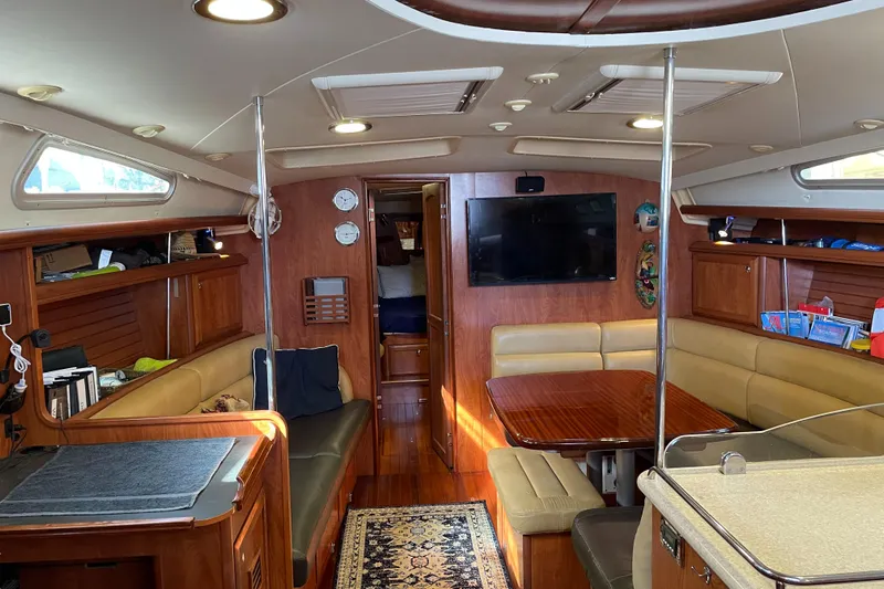 Sailing Diver Yacht Photos Pics Luxurious interior of 2010 Hunter 49 Aft Cockpit yacht with wood finish and seating area.