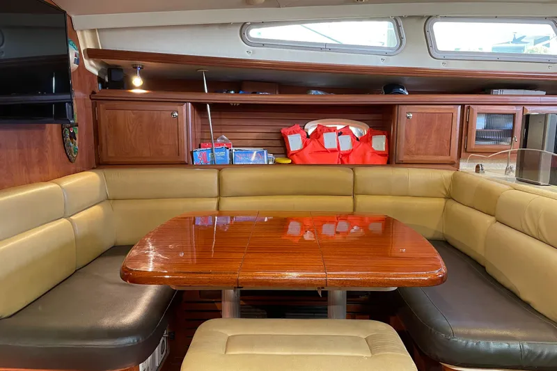 Sailing Diver Yacht Photos Pics Interior of 2010 Hunter 49 Aft Cockpit yacht with wooden table and cushioned seating.
