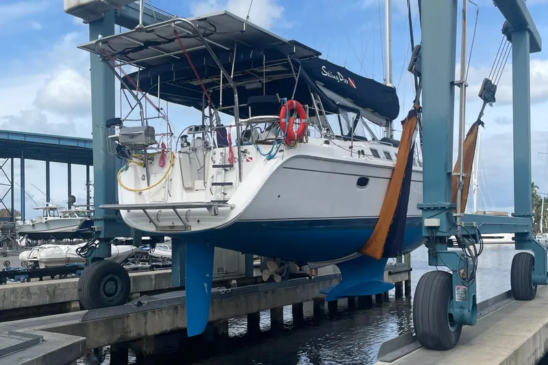 Sailing Diver Yacht Photos Pics 2010 Hunter 49 Aft Cockpit sailboat on lift at marina, blue hull, overcast sky.