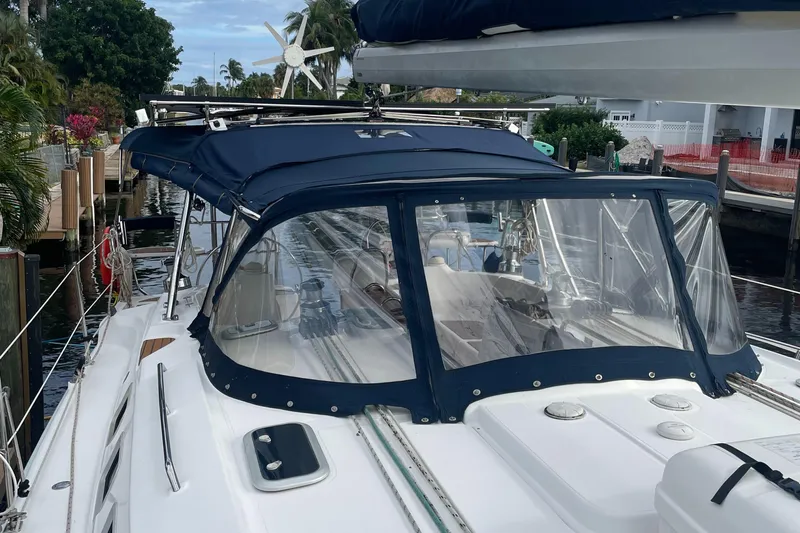 Sailing Diver Yacht Photos Pics 2010 Hunter 49 Aft Cockpit sailboat with blue canopy docked in a marina.