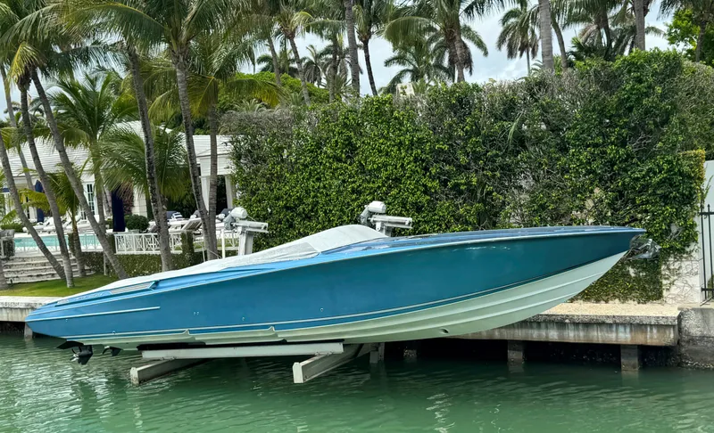  Yacht Photos Pics 2013 Nor-Tech 420 Monte Carlo boat docked by lush greenery and palm trees.