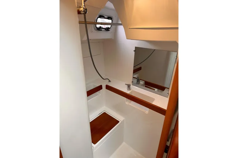 Grey Havens Yacht Photos Pics 2017 Beneteau Oceanis 38.1 yacht bathroom with shower, mirror, and wooden accents.
