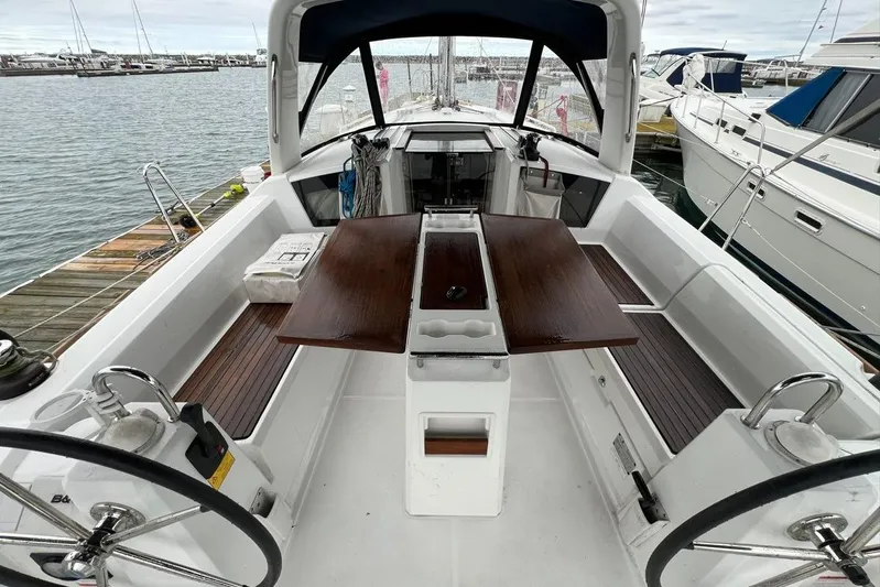 Grey Havens Yacht Photos Pics 2017 Beneteau Oceanis 38.1 sailboat cockpit with wooden table, docked at marina.