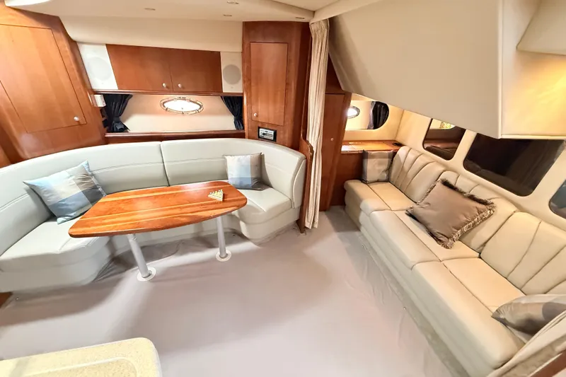 Ursula Yacht Photos Pics Luxurious interior of 2006 Cruisers Yachts 370 Express with elegant seating and wooden table.