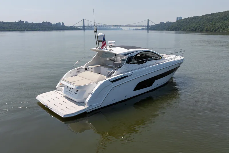  Yacht Photos Pics 2023 Azimut Atlantis 45 yacht cruising on a calm river with a bridge in the background.