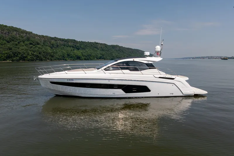  Yacht Photos Pics 2023 Azimut Atlantis 45 yacht on calm water, surrounded by lush greenery.