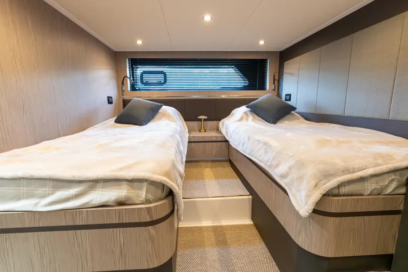  Yacht Photos Pics Luxurious twin cabin interior of 2023 Azimut Atlantis 45 yacht, featuring modern design and cozy bedding.