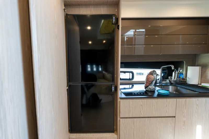  Yacht Photos Pics Modern kitchen interior of 2023 Azimut Atlantis 45 yacht, featuring sleek cabinetry and appliances.