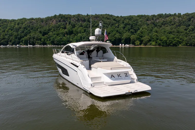  Yacht Photos Pics 2023 Azimut Atlantis 45 yacht on calm water, lush green forest background.