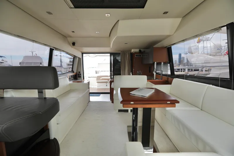 Perseus Yacht Photos Pics Interior of 2013 Prestige 500 yacht with white seating and wooden table.