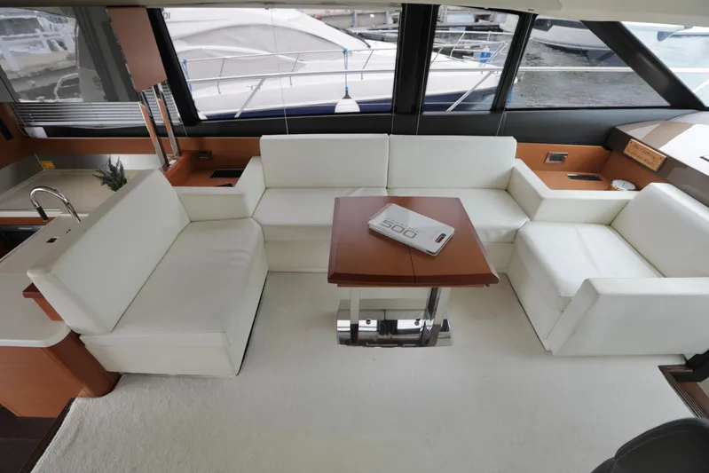 Perseus Yacht Photos Pics Luxurious interior of a 2013 Prestige 500 yacht with white seating and a wooden table.