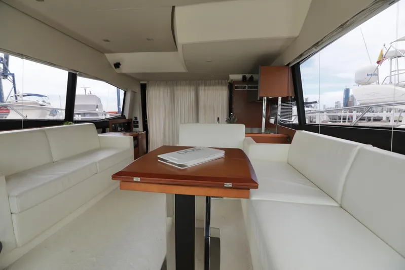 Perseus Yacht Photos Pics Interior of 2013 Prestige 500 yacht with white seating and wooden table.