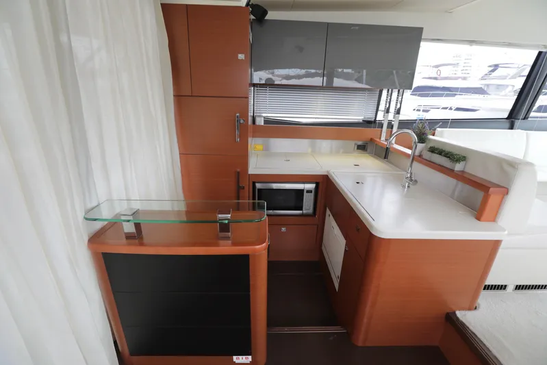 Perseus Yacht Photos Pics Modern kitchen area in a 2013 Prestige 500 yacht with wood cabinetry and white countertops.