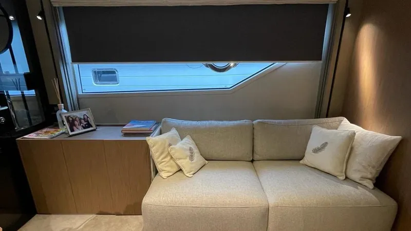  Yacht Photos Pics Luxurious interior of 2023 Ferretti Yachts 720 with elegant sofa and window view.