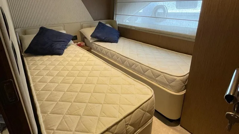  Yacht Photos Pics Twin beds in a luxurious 2023 Ferretti Yachts 720 cabin with blue pillows.