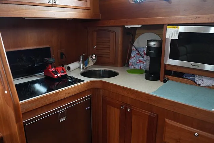 Melissa Marie 2 Yacht Photos Pics 2006 Sabre 38 Hardtop Express galley with wood cabinetry, sink, stove, and microwave.