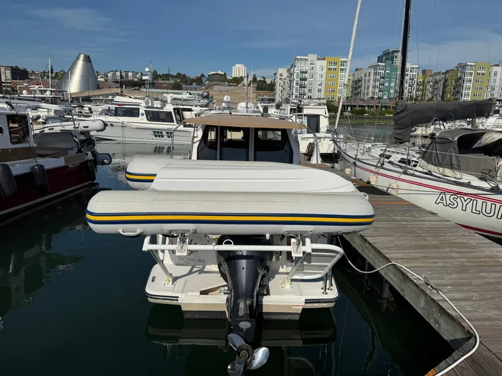  Yacht Photos Pics 2021 Ranger Tugs R-27 docked at marina with inflatable boat on stern.
