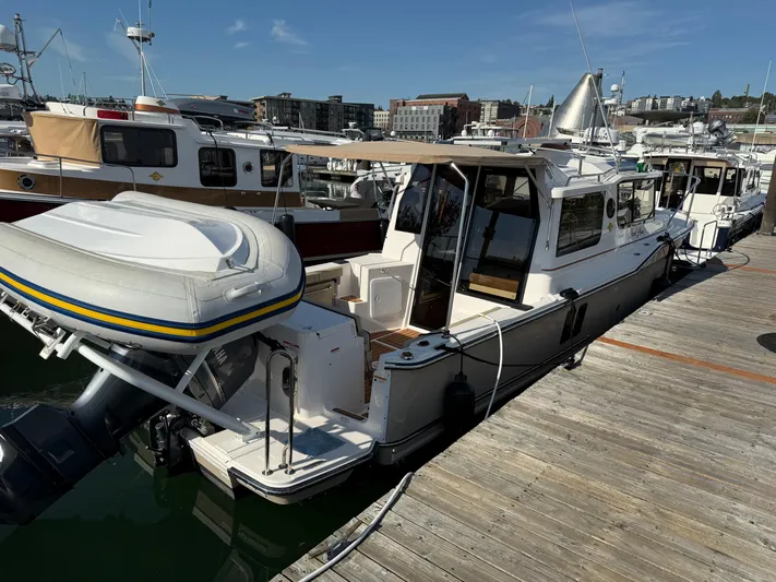  Yacht Photos Pics 2021 Ranger Tugs R-27 docked at marina with inflatable boat attached.