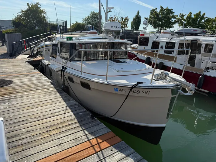  Yacht Photos Pics 2021 Ranger Tugs R-27 docked at a marina, showcasing sleek design and modern features.
