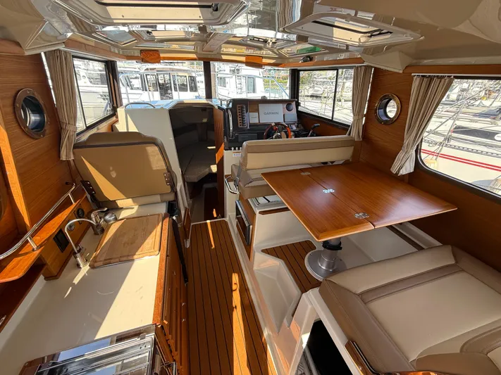  Yacht Photos Pics 2021 Ranger Tugs R-27 interior with wood finishes, dining area, and helm station.