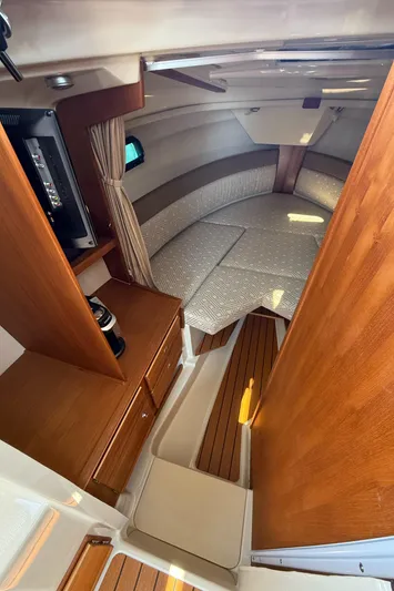 Yacht Photos Pics 2021 Ranger Tugs R-27 cabin interior with cozy seating and wooden cabinetry.