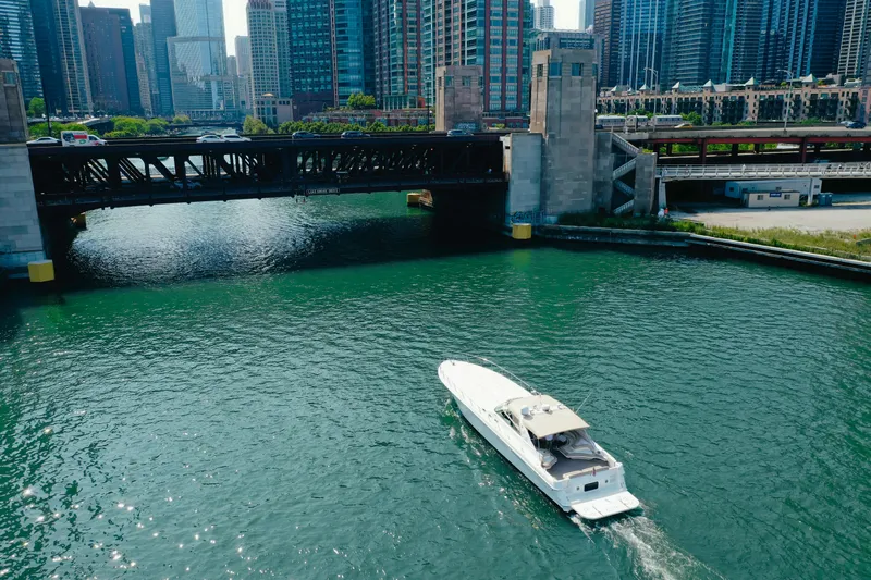  Yacht Photos Pics 1997 Sea Ray 630 Super Sun Sport cruising under a city bridge with skyscrapers in the background.