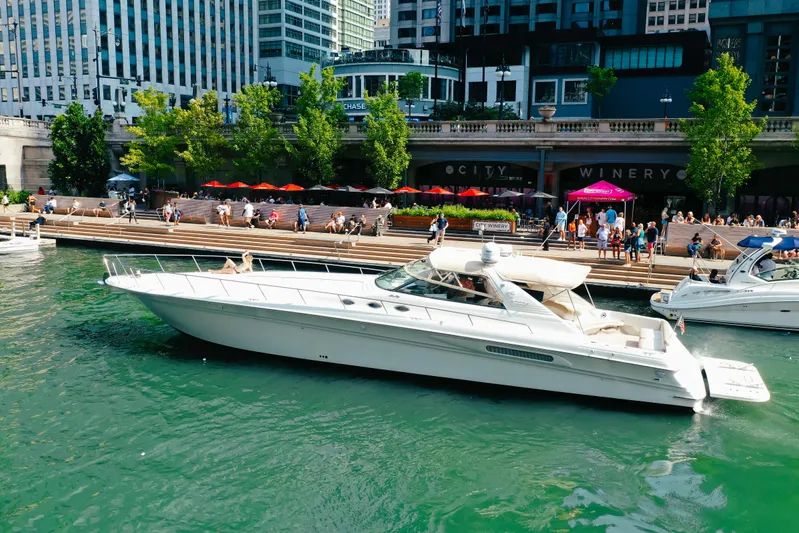  Yacht Photos Pics 1997 Sea Ray 630 Super Sun Sport yacht docked near a bustling waterfront cityscape.